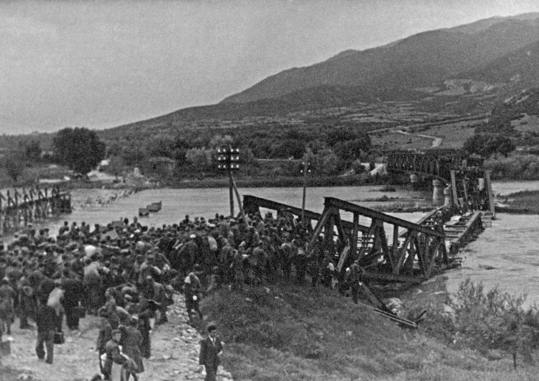 Περιοχή Σερρών, τέλη Απριλίου - αρχές Μάϊου 1941. Έλληνες αιχμάλωτοί επιστρέφουν στην Ελλάδα περνώντας επάνω από την κατεστραμμένη γέφυρα του Στρυμόνα