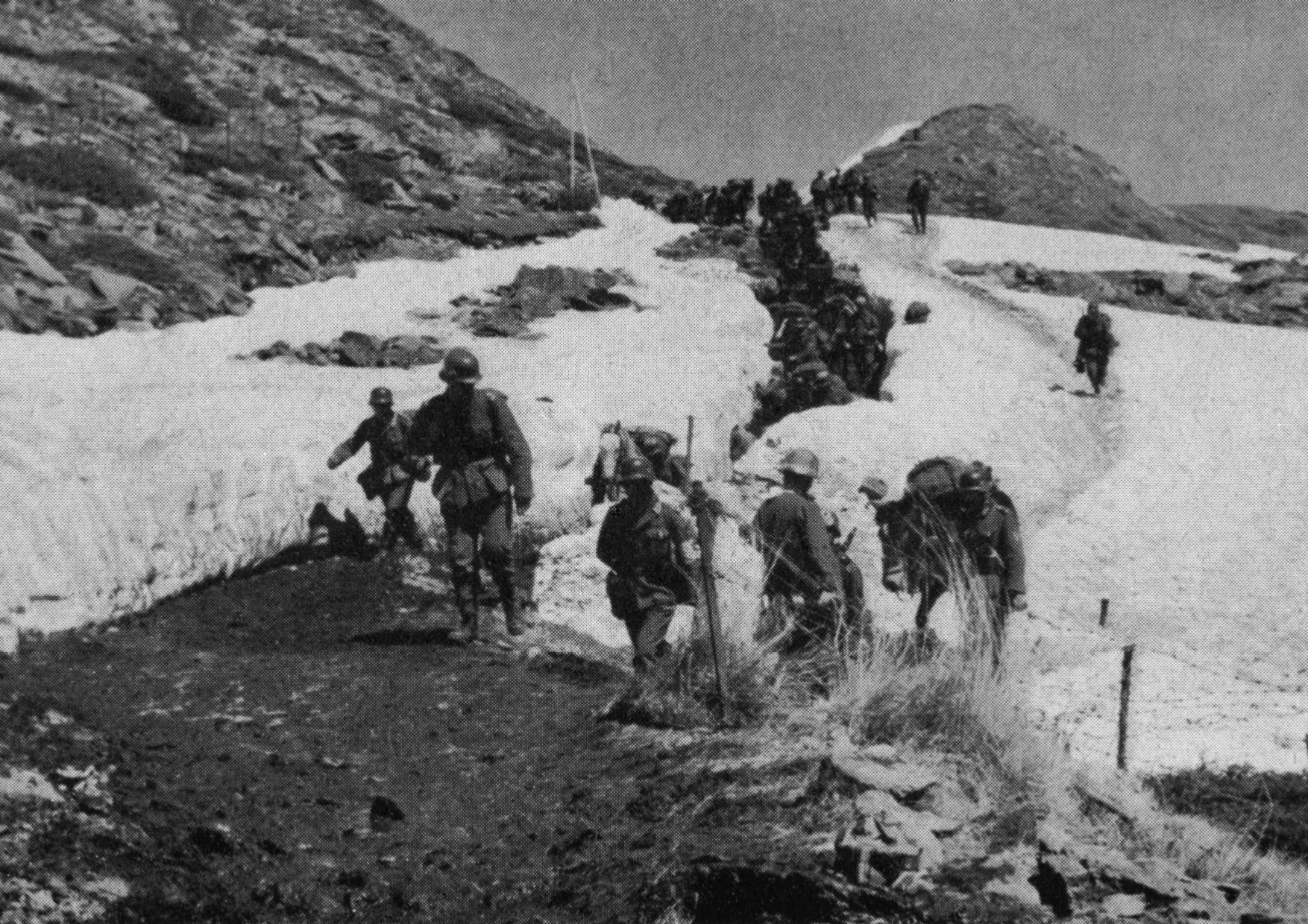 Περιοχή Σερρών, 6 Απριλίου 1941. Ομάδα ορεινών Γερμανών καταδρομέων ξεπροβάλλουν μέσα το χιονισμένο πέρασμα του Δεμίρ Καπού, καθώς προελαύνουν προς την Ομορφοπλαγιά