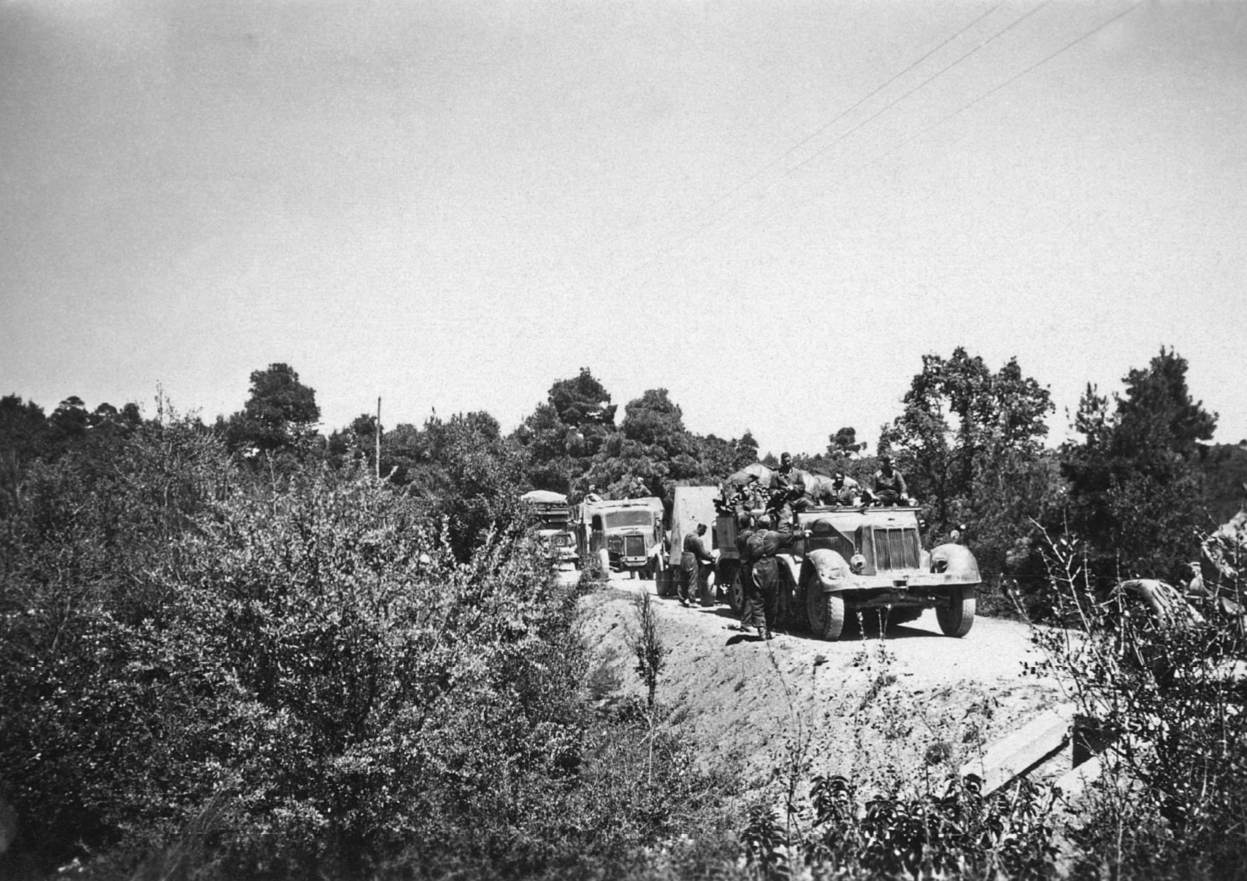 6 Απριλίου 1941. Γερμανοί στρατιώτες έχουν φτάσει στο ελληνικό έδαφος και κατεβαίνουν από τα οχήματά τους για να πάρουν θέσεις μάχης απέναντι από κάποιο ελληνικό οχυρό της Γραμμής Μεταξά