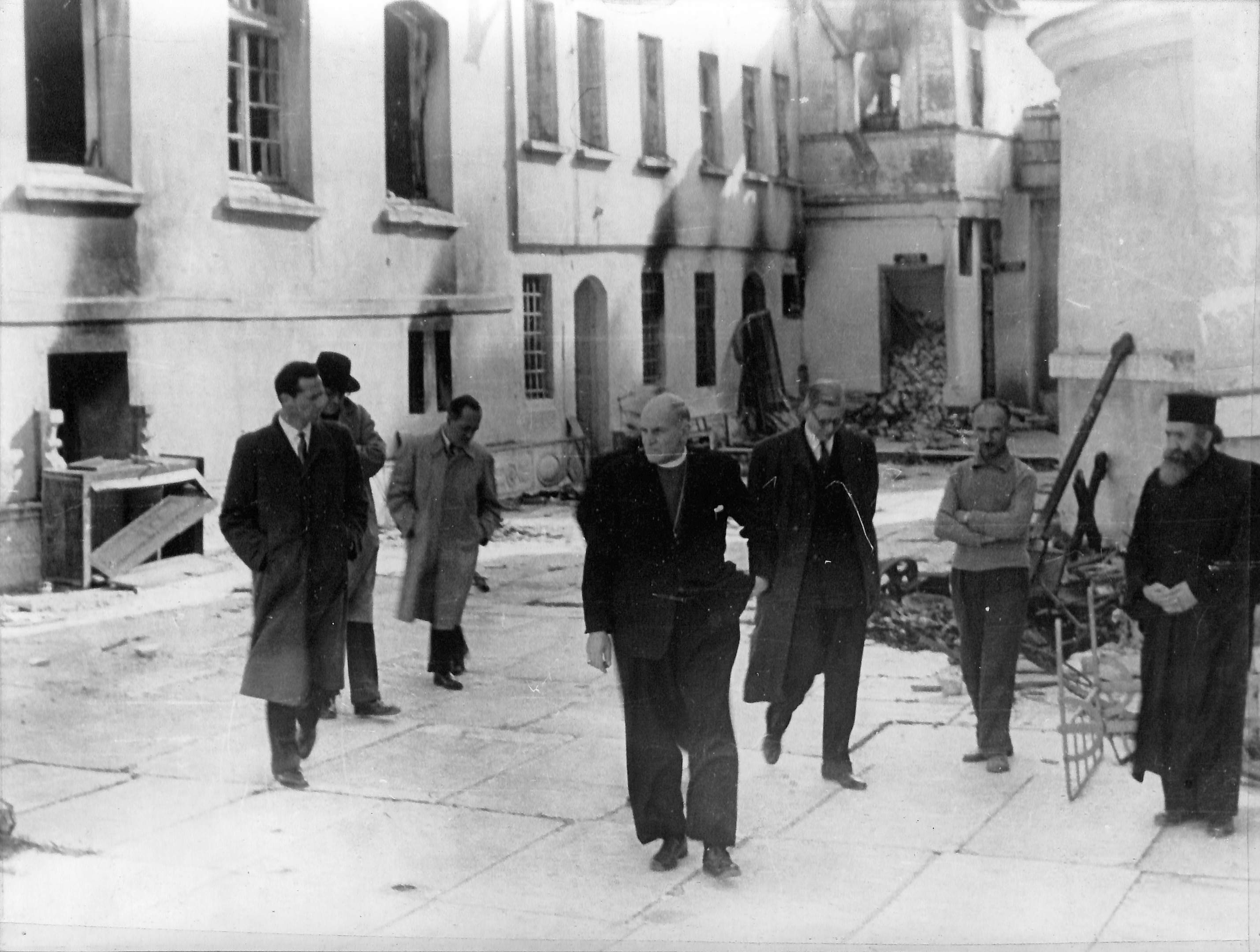 Ο Δρ. Ταφτ και η συνοδεία του περιεργάζονται τι κατεστραμμένο κτίριο της μονής και το κελί του φονευθέντα ιερέα Χρύσανθου