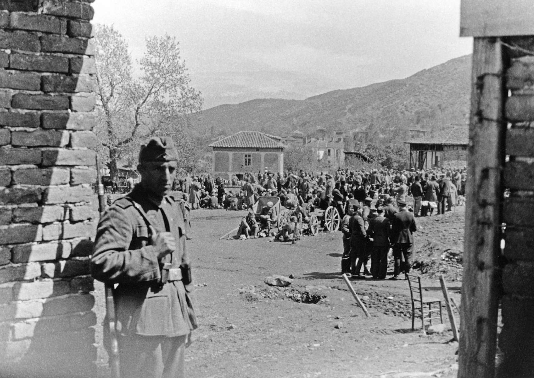 Απρίλιος 1941. Η είσοδος του στρατοπέδου Ελλήνων και Σέρβων αιχμαλώτων στο Πετρίτσι Σερρών. Σε πρώτο πλάνο Γερμανός φρουρός