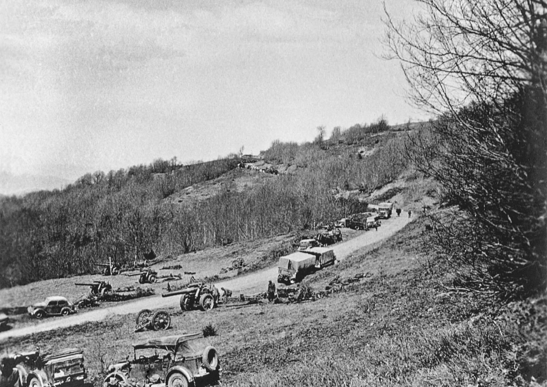 6 Απριλίου 1941. Γερμανική πυροβολαρχία έχει πάρει θέση στα μετόπισθεν και ετοιμάζεται να βάλει κατά της Γραμμής Μεταξά προς υποστήριξη των πεζοπόρων τμημάτων που επιτίθενται στα οχυρά