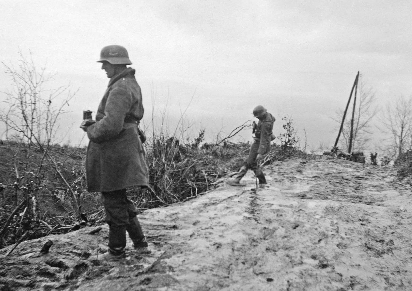 Περιοχή Σερρών, Απρίλιος 1941. Δύο όρθιοι Γερμανοί στρατιώτες μπροστά σε ελληνικό οχυρό του Υποτομέα Στηρίγματος φωτογραφίζουν τις επιχειρήσεις στο πεδίο μάχης